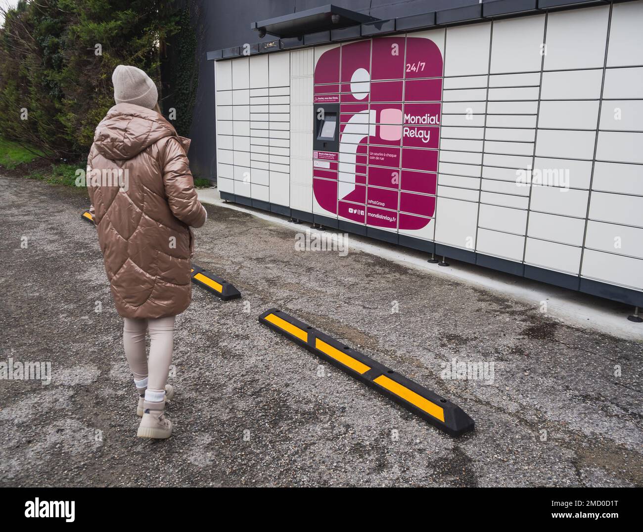 Loriol sur Drome, Frankreich - 14. Januar 2023: Abholung eines Pakets aus einem Mondial`Relay-Schließfach durch eine junge Frau. Schließfächer Mondial Relay. Pickup-Box. Stockfoto